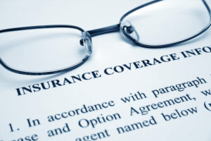 Glasses laying on insurance coverage information