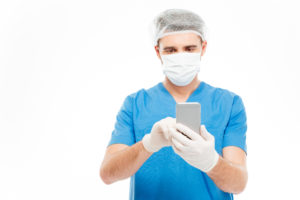 Male surgeon using smartphone