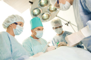 Surgeons looking down at patient in operating room