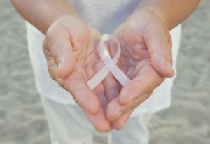 Hands holding pink breast cancer ribbon