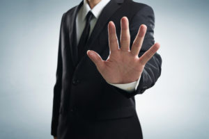 Person in suit with a hand stop shown